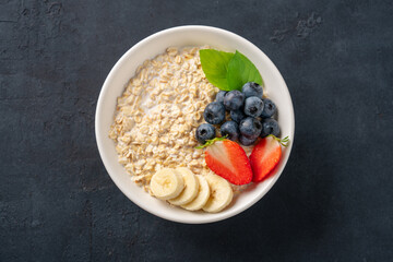 Milk porridge prepared for breakfast with blueberries, strawberries and bananas