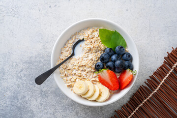 Milk porridge prepared for breakfast with blueberries, strawberries and bananas