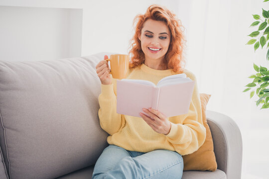Photo of positive good mood woman dressed yellow sweater drinking tea enjoying intersting story indoors house apartment room