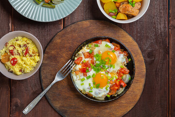 Jewish food tzimmes, chelnt, shakshuka for the holiday next to a fork
