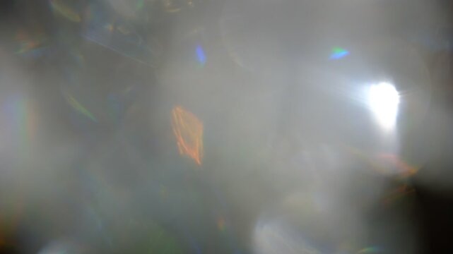 Multicolored Glittering abstract flares bokeh background. Blurry abstract fairy light background with bokeh. Caustic light, refraction.