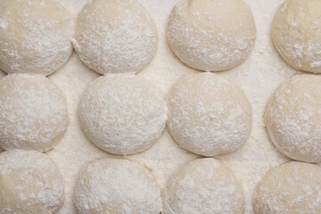 Massa de pão e pizza espelhadas com farinha, tudo numa mesa de pizzaollo