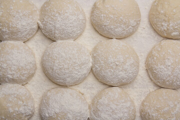 Massa de pão e pizza espelhadas com farinha, tudo numa mesa de pizzaollo