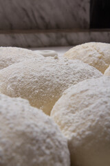 Massa de pão e pizza espelhadas com farinha, tudo numa mesa de pizzaollo