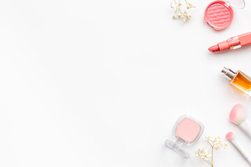 Flat lay of makeup cosmetic products and accessories in brown pink shades, top view. Powder, blush and lipstick