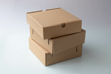 Three brown narrow cardboard boxes on a white background