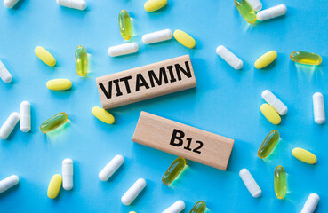 Vitamin B12 symbol. Concept word Vitamin B12 on wooden blocks. Beautiful blue background with...