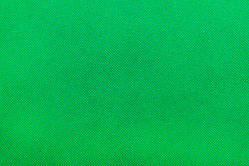 a close-up of a green fabric featuring a fine textured pattern.