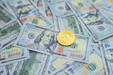 A Bitcoin token placed on America one hundred dollars banknote.