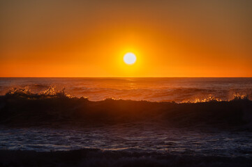 Golden sunset over the ocean, vibrant orange sky, peaceful and serene nature scene