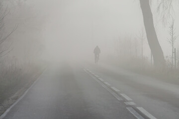 road during morning fog. Bad weather conditions while driving will occur in autumn and winter. poor...
