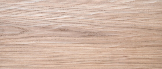 A wooden surface with a grainy texture. The wood is light brown in color. The surface is smooth and has a natural look