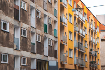 Fototapeta premium architecturally interesting apartment blocks in the city center on the street. old construction of blocks of flats made of large panels. contrast of the building after renovation with the building bef