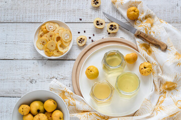Home made quinces syrup on a white table shot from above. Preparing the preserve of natural source of vitamin C 