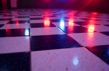 Checkered Dance Floor with Colorful Lighting. Close-up of a glossy checkered black-and-white dance floor illuminated by red and blue lights, creating a vibrant and modern ambiance.
