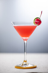 A refreshing red cocktail garnished with a cherry and lime wedge. Perfect for a summer party.
