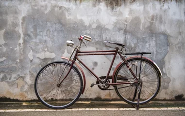  Vintage bicycle on old rustic dirty wall house, many stain on wood wall. Classic bike old bicycle on decay brick wall retro style. Cement loft partition and window background. © BESTIMAGE