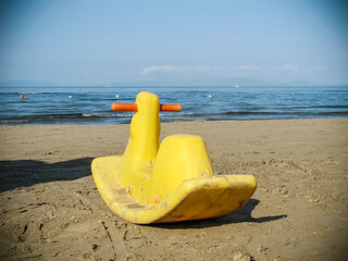 Yellow plastic duck on a beach 