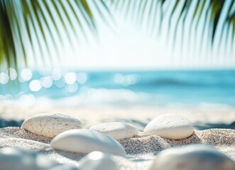 Photo of a summer background with white stones on sand and a blue sea, with a blurred palm tree in the foreground.