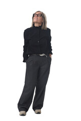 Fototapeta premium Front view of a woman dressed in dark clothing with hands in pockets looking up on white background