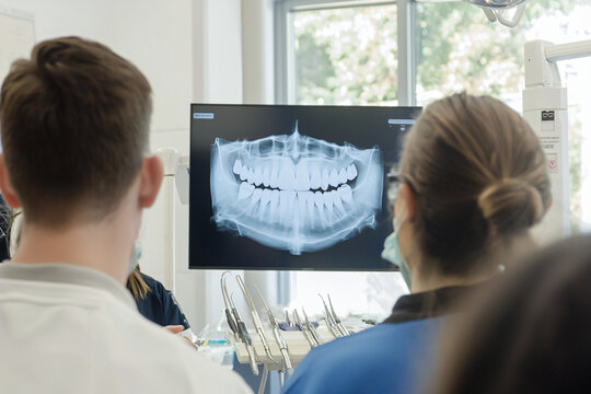 dental technology demonstration, students taking notes, advanced equipment displayed
