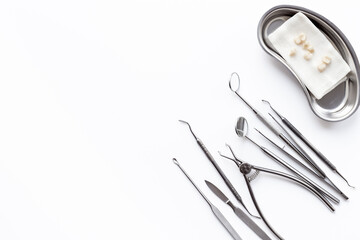 Dental steel instruments for dental prosthetics and oral treatment on a white background. Dentist desk top view
