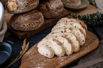 Artisan Batard Sourdough healthy Bread with leaf scoring. Open crumb high hydration Sourdough bread set on white table.