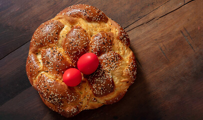 Easter bread, greek tsoureki braid and red easter eggs on table