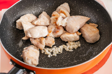 フライパンで炒めるニンニクと鶏むね肉