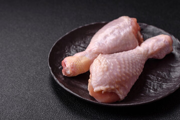 Raw chicken legs with salt, spices and herbs