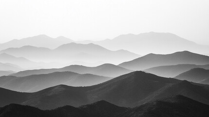 Majestic mountain range with layers of mist and shadow in monochrome tones