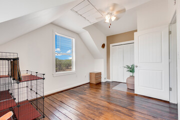 Spacious living room with wooden flooring and sliding doors leading to a bright outdoor area