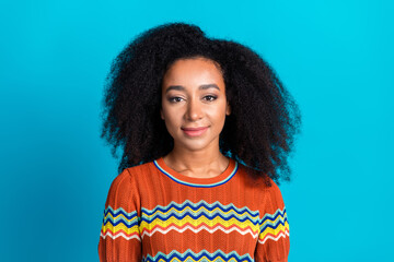 Stylish young woman in a trendy striped t-shirt against a vibrant blue background