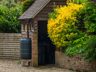 Rain barrel in the garden, environmentally friendly rain water harvesting and reusage