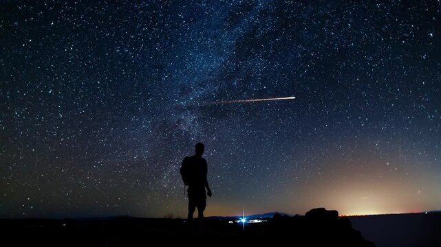 person watching night sky and a shooting star.