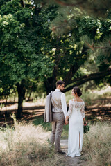 Fototapeta premium guy and a girl newlyweds are walking in the forest