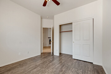 Spacious living room with wooden flooring and sliding doors leading to a bright outdoor area