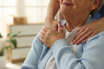 Caregiver supporting senior woman indoors, closeup. Home health care service