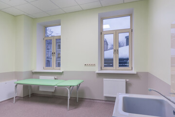 Fototapeta premium A bright clinic office with a sink and a couch for examining patients.