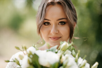 Fototapeta premium young girl in a beautiful tight dress with a bouquet