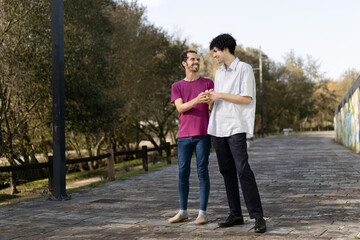 Obraz premium Brazilian gay couple holding hands and showing love in a park