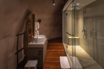 This modern bathroom features a stunning glass shower, elegant sinks, and warm wood accents, creating a calming atmosphere for relaxation after a long day