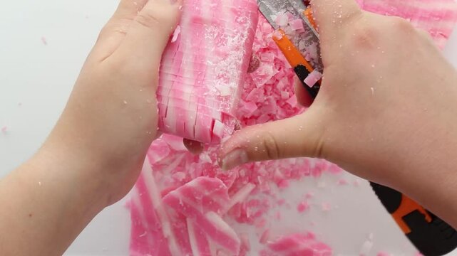 The girl's hands grind colored soap into small pieces with a sharp knife. View from above. Asmr. The trigger. an external and audible stimulus for relaxation. Part 5
