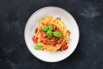 Traditional italian food - spaghetti bolognese with fresh basil leaves and parmesan cheese, top view	