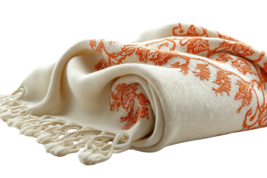 Soft cream colored shawl with intricate orange pattern draped elegantly over itself
