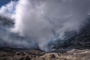 A breathtaking and stunning view of a powerful Bromo volcanic eruption, with thick clouds of smoke and ash rising dramatically, showcasing the immense raw power of nature, East Java, Indonesia