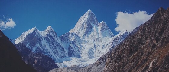 Majestic mountain peaks with jagged edges and snow-covered summits against a clear blue sky