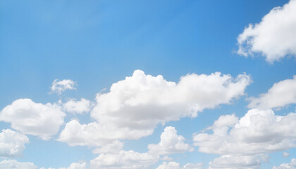 Fototapeta premium Fluffy clouds drift across a clear blue sky, serenity in nature