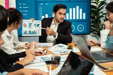 Diverse group of business analyst team analyzing financial data report. Finance data analysis chart and graph dashboard show on TV screen in meeting room for strategic marketing planning. Habiliment