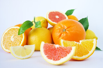 Oranges, grapefruits and lemons with slices on isolated white background